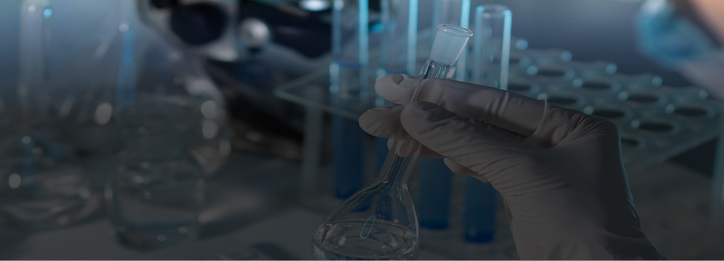 Mano sosteniendo un frasco en un laboratorio científico.